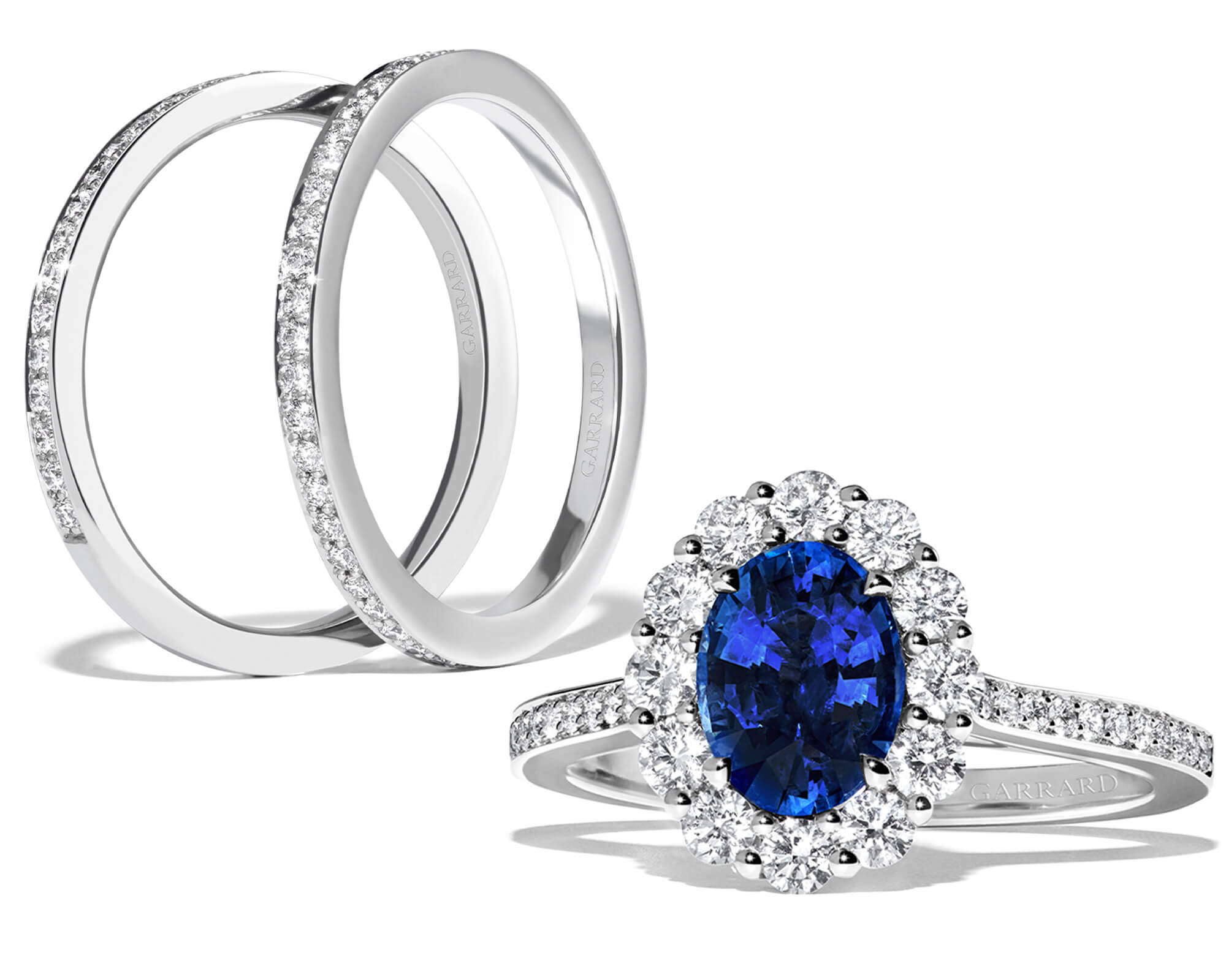 Close up of a Garrard 1735 sapphire cluster engagement ring with 1735 wedding bands apart