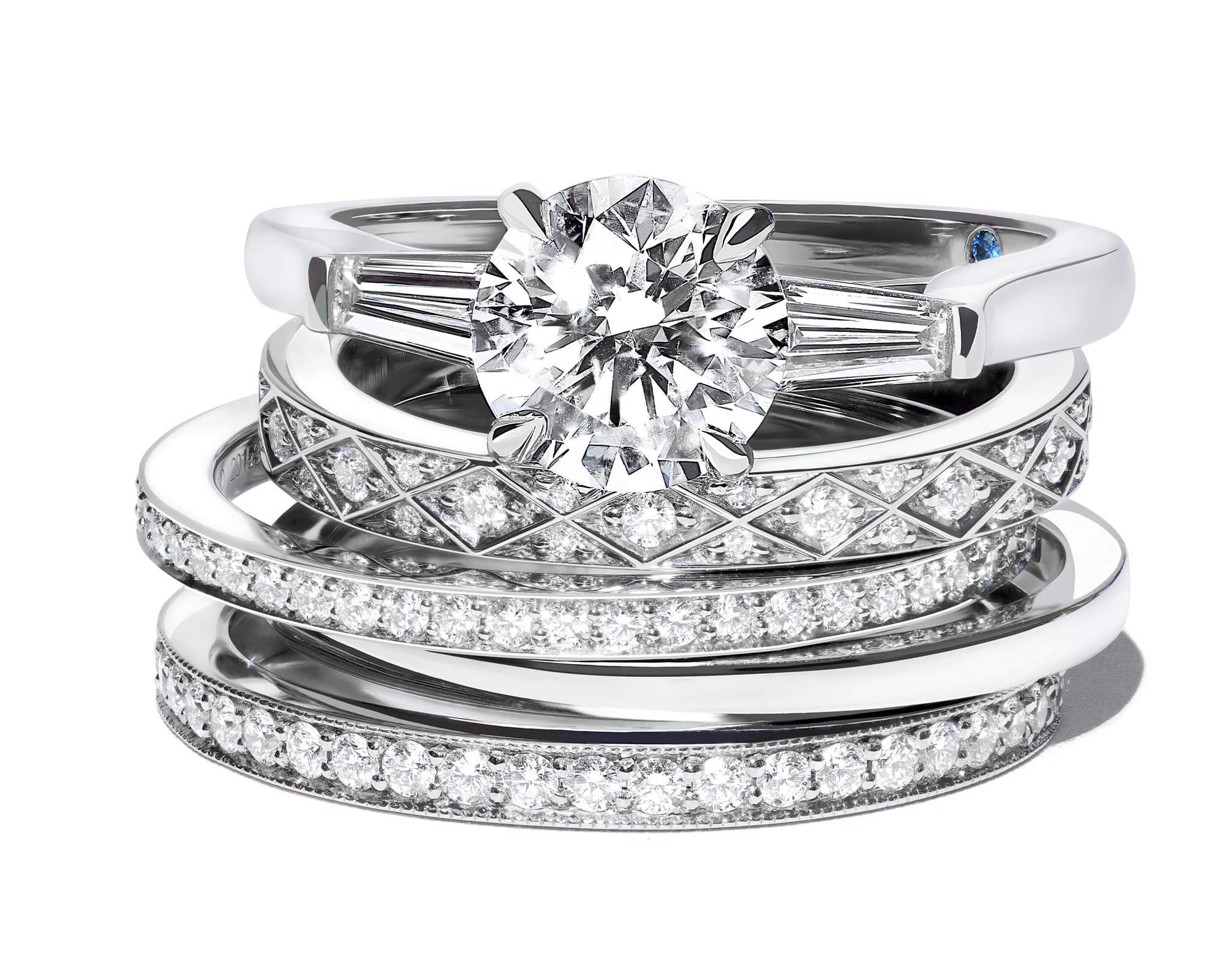 close up of a Garrard Charisma diamond engagement ring witha stack of wedding bands