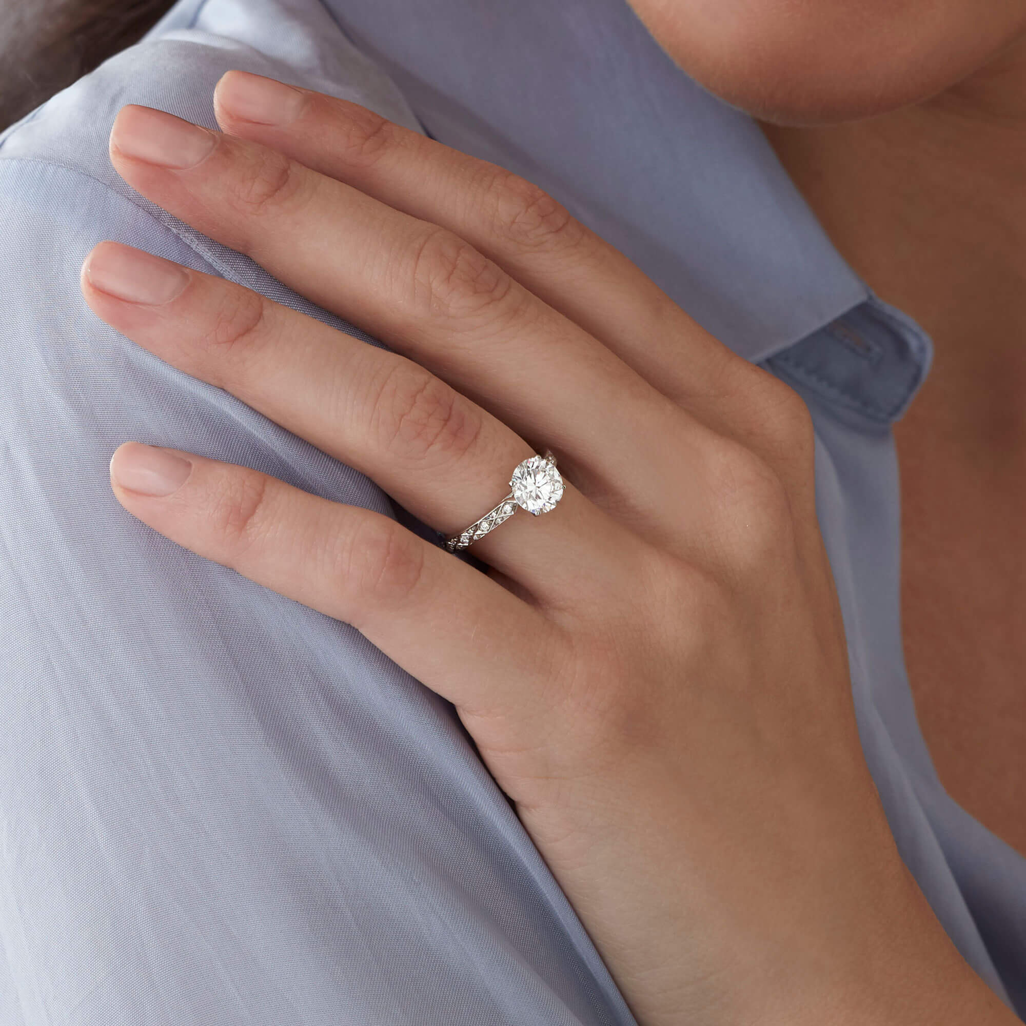 Close up of a model wearing a Garrard Bridal Collection Signature round diamond engagement ring 1